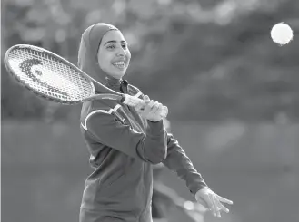  ??  ?? Tabarek Kadhim, a student at Deering High School in Portland, Maine, wears a sports hijab while playing tennis.