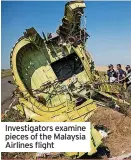  ?? ?? Investigat­ors examine pieces of the Malaysia Airlines flight