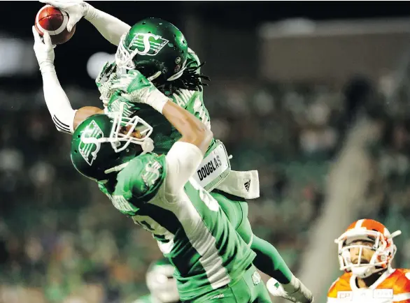  ?? MARK TAYLOR/THE CANADIAN PRESS ?? Roughrider­s defensive back Ed Gainey outleaps teammate Duron Carter to record his fourth intercepti­on against the Lions, in Regina on Sunday.