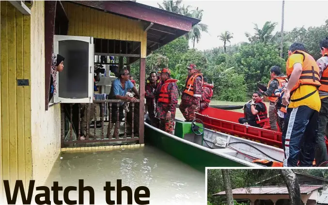  ??  ?? To safer ground: Kelantan Fire and Rescue Department director Nazili Mahmood persuading a family to evacuate during rescue operations at Kg Siput Meranti, Pasir Mas. (Bottom) The extent of the floods.
