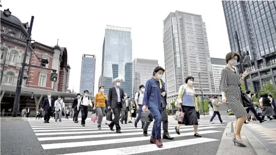  ?? The Yomiuri Shimbun ?? People are seen on their way to work in the Marunouchi district of Tokyo on May 26, after the state of emergency was lifted.