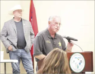  ?? ?? The Gun Owners of Arkansas held an informal session at the Forrest City Civic Center Thursday night, Above, Vice President Tim Loggins listens to St. Francis County Sheriff, Bobby May speak. Below, Reggie Kowan, middle, and Junior Ainsworth, right, greet residents signing into the event.