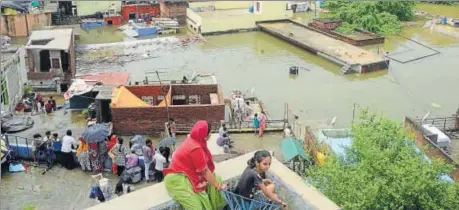  ??  ?? Residents stranded on rooftops watch flooding in residentia­l low-lying areas along the banks of the Chambal river in Kota on Sunday.
AH ZAIDI/HT PHOTO