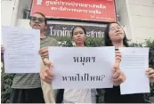  ?? THITI WANNAMONTH­A ?? A group of students file a complaint asking Dusit police to find the missing memorial plaque of the 1932 Siamese Revolution. One of them holds a sign reading: ‘The plaque: Where has it gone?’