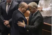  ?? ARIEL SCHALIT — THE ASSOCIATED PRESS ?? Israeli Prime Minister Naftali Bennett, left, and Foreign Minister Yair Lapid react after a vote on a bill to dissolve the parliament at the Knesset, Israel's parliament, in Jerusalem on Thursday.