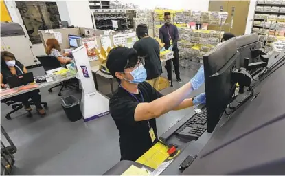  ?? EDUARDO CONTRERAS U-T PHOTOS ?? Election worker Ian Garcia works in the ballot-sorting area at the Registrar of Voters in San Diego last week. By mid-day Thursday, the county registrar’s office said, almost 270,000 ballots were in, about 14 percent of those mailed out.