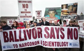  ??  ?? Local TD Shane Cassells (centre) with Ballivor residents at a protest against Scientolog­y outside the old national school in the village. Photo: Tony Gavin