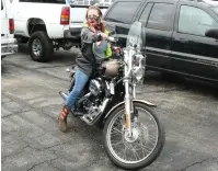  ??  ?? The Sentinel-Record/Richard Rasmussen
Potential buyer Monica Womack, of Hot Springs, sits on a Harley-Davidson motorcycle up for auction at the 18th Judicial District East Drug Task Force auction at the Bill Edwards Center Friday.