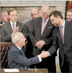  ?? Arkansas Democrat-Gazette/JOHN SYKES JR. ?? Gov. Asa Hutchinson shakes hands with state Sen. Jonathan Dismang on Tuesday after signing the measure cutting taxes for the state’s top earners. Dismang sponsored the bill.