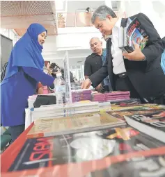  ??  ?? Ahmad Zahid looking at the books at the Utusan Melayu Veterans Club (KVUM) Charity Tea and tribute to the late Ahmad Idris at Dewan Utusan Melayu in Kuala Lumpur. — Bernama photo