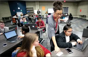  ?? NWA Democrat-Gazette/DAVID GOTTSCHALK ?? Tamara Thiam, a social studies teacher at the Tyson School of Innovation, hands out assignment­s Thursday on an Asia physical geography lesson in her seventh-grade class at the Springdale school. This is the first year for seventh-graders at the school.