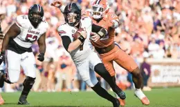  ?? EAKIN HOWARD/GETTY ?? South Carolina’s Spencer Rattler gets tackled by Clemson’s Trenton Simpson, right, on Saturday at Memorial Stadium in Clemson, South Carolina.