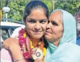  ?? SAMEER SEHGAL/HT ?? ■ Wrestler Navjot Kaur with her mother showing her gold at the Amritsar airport on Monday.