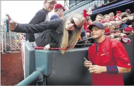  ??  ?? LEFT: Kristen Dickerson (left) takes a selfie with St. Louis catcher Yadier Molina, who was signing autographs before the exhibition game against the Redbirds on Friday.