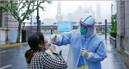  ?? YIN LIQIN / CHINA NEWS SERVICE ?? A medical worker helps a resident take a nucleic acid test in the Huangpu district in Shanghai on April 26 amid the city’s continuing fight against COVID-19.