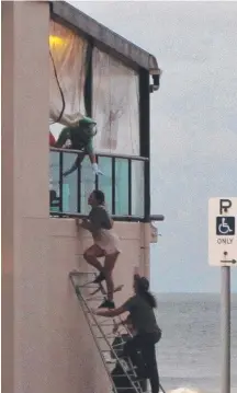  ??  ?? People using a makeshift ladder to get into the Tugun Surf Life Saving Club during the national titles.