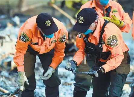  ?? JOSH EDELSON — AGENCE FRANCE-PRESSE VIA GETTY IMAGES ?? A search-and-rescue team looks for bodies Thursday at a property where a person was reported missing in Santa Rosa. Of 1,000people reported missing, officials have found about 600. With evacuees spread throughout the region and communicat­ion hampered,...