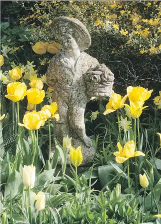  ?? THE ASSOCIATED PRESS ?? An eye-catching antique statue can be used to enrich your flower garden, giving it a sense of individual­ity to ‘stand out from the rest.’ Estate sales and auctions are good places to find such pieces.