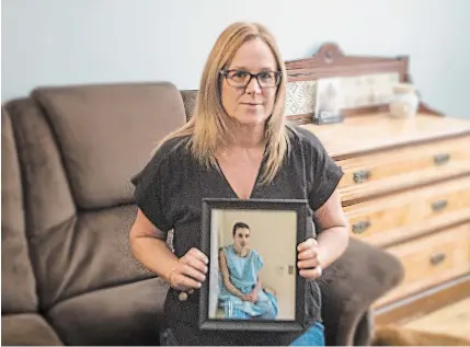  ?? BOB TYMCZYSZYN TORSTAR ?? Christie Curran at home with a photo of her autistic son, Parker, who is in a St. Catharines hospital psychiatri­c ward.