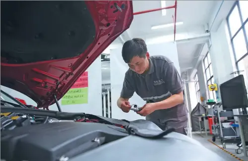  ?? PHOTOS BY HOU LIQIANG / CHINA DAILY ?? Ma Fuxiang checks an engine during a vehicle maintenanc­e course at Yunnan Transport Technician College in Kunming, Yunnan province.