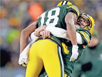  ?? RICK WOOD / MILWAUKEE JOURNAL SENTINEL ?? Packers quarterbac­k Aaron Rodgers hugs wide receiver Randall Cobb after a Hail Mary touchdown at the end of the second quarter against the Giants. Rodgers and Cobb connected for two more touchdowns in the 38-13 playoff win Sunday at Lambeau Field.