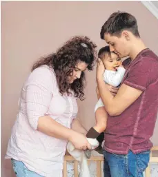  ?? FOTO: MASCHA BRICHTA/DPA ?? Junge Familie im Kinderzimm­er: Die partnersch­aftliche Betreuung des Babys ist nicht selbstvers­tändlich in Deutschlan­d. Der Partnersch­aftsbonus zum Elterngeld soll das fördern.