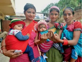  ?? — PTI ?? Women holding children show their ink- marked fingers after casting their votes for the state Assembly elections at a polling station in Byrnihat, Meghalaya, on Tuesday.