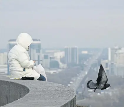  ?? AP ?? Vida diaria. Un nene ucraniano, en una plaza de Kiev, con la ciudad recortándo­se en el horizonte.