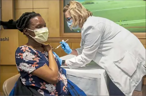  ?? Alexandra Wimley/Post-Gazette ?? Charity Kwamanakwe­enda, of Cranberry, receives a COVID-19 vaccine from Beth Quinn, director of women’s health operations at UPMC Magee-Womens Hospital, during a vaccine clinic for pregnant women Wednesday at the hospital in Oakland.