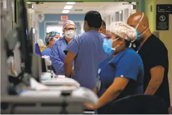  ?? DANIA MAXWELL LOS ANGELES TIMES ?? Doctors and nurses treating COVID-19 patients in a makeshift ICU wing Dec. 29 at Harbor-UCLA Medical Center near Torrence. The hospital has no open beds for incoming patients.