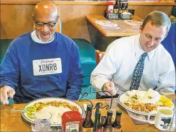  ?? California Innocence Project ?? HORACE ROBERTS sits down to his first meal after leaving California’s Avenal State Prison. Michael Semanchik, right, of the California Innocence Project joins him. The organizati­on worked to exonerate Roberts.