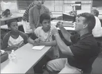  ?? Brendan McGair/The Call ?? Dave Belisle fields questions from Kalil Fofana, 12, of Pawtucket, left, and Harrison Usma, 13, of Central Falls, while sitting at a table in a classroom on Bryant University’s campus on Monday.