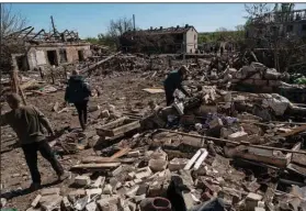  ?? (The New York Times/Lynsey Addario) ?? Residents look through the debris of their homes Saturday in Malotarani­vka, Ukraine, after a Russian strike on the small village near Kramatorsk.