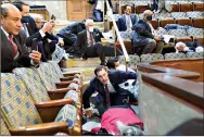  ?? (AP Photo/ Andrew Harnik) ?? People take shelter as protesters try to break into the U.S. House of Representa­tive Chamber at the Capitol on Wednesday in Washington.