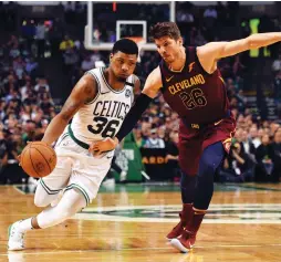  ??  ?? BOSTON CELTICS guard Marcus Smart (left) drives against Cleveland Cavaliers defender Kyle Korver during the third quarter of the Celtics 107-94 home victory over the Cavs on Tuesday night to take a 2-0 lead in the Eastern Conference finals.