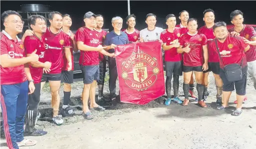  ?? ?? PEMINAT MU: Dr Annuar (tujuh kiri) bersama peminat kelab bola sepak Manchester United (MU) pada majlis prapelanca­ran padang bola sepak baharu di Kemuyang, Sibu malam kelmarin.