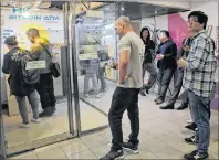  ?? KIN CHEUNG/THE ASSOCIATED PRESS ?? People line up and wait to use the Bitcoin ATM in Hong Kong, Friday.