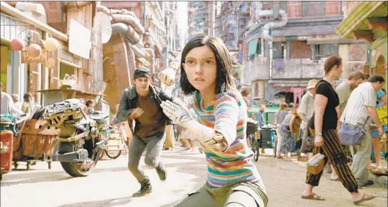  ?? 20th Century Fox ?? A YOUNG street ruffian (Keean Johnson, left) comes to the aid of Alita (Rosa Salazar) on the gritty streets of Iron City in Robert Rodriguez’s “Alita: Battle Angel.”