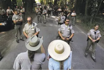  ?? Kent Porter / Associated Press 2006 ?? Protesters talk to Sonoma County sheriff ’s deputies and California Highway Patrol officers at the Bohemian Grove in Monte Rio in 2006.