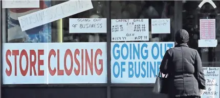  ?? NAM Y. HUH/AP ?? A woman looks at signs Wednesday at a store closed due to the COVID-19 pandemic in Niles, Ill.