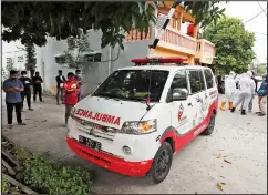  ??  ?? Volunteers join relatives to pray near an ambulance carrying the body of a covid-19 victim.