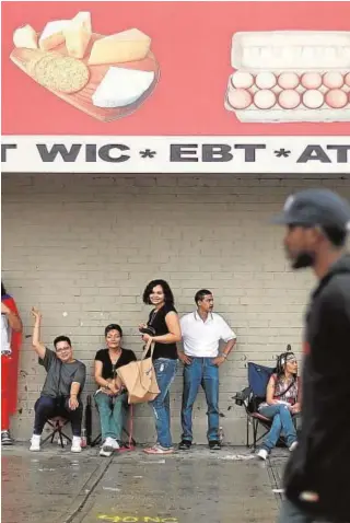  ?? // ABC ?? Un grupo de puertorriq­ueños se protege de la lluvia en Harlem