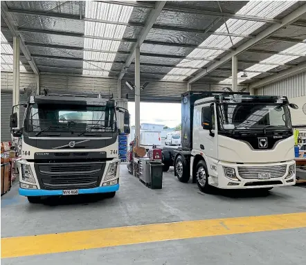  ?? ?? Fonterra’s new e-tanker, at right, being fitted out at its Morrinsvil­le garage. The company will be trialling the first modern electric milk tanker over the next dairy season.