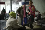  ?? FRANCISCO SECO — THE ASSOCIATED PRESS ?? Maria Nebula, 84, is helped as she leaves a reception center for displaced people for a nursing home, in Dnipro, Ukraine, Thursday.