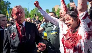  ?? ?? Activists shout slogans as Russian Ambassador to Poland, Sergey Andreev, left, is covered with red paint in Warsaw, Poland, on Monday as he arrived at a cemetery in Warsaw to pay respects to Red Army soldiers who died during World War II. — ap