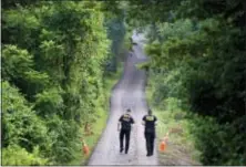  ?? AP PHOTO/MATT ROURKE ?? Pennsylvan­ia State Police officers walk up a driveway, Friday, July 14, 2017, in Solebury, Pa., as the investigat­ion of four missing young Pennsylvan­ia men continues.