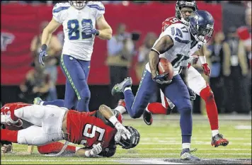  ??  ?? Former Falcons kick returner Devin Hester leaves would-be tackler LaRoy Reynolds on the ground as he races for a big gain. Hester returned a Falcons kickoff 78 yards, setting up a Seahawks touchdown, and had another, 50-yard return. — MICHAEL CUNNINGHAM