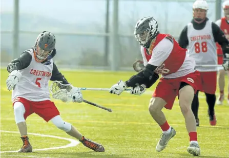  ?? CLIFFORD SKARSTEDT/EXAMINER ?? Crestwood Mustangs' Nick Darrington hangs onto the ball against Stanstead College during the opening game of the third annual Crestwood Lax Classic lacrosse tournament on Wednesday at the Fleming Sport Field Complex. Crestwood made it to the finals but...