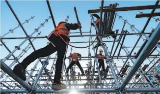  ?? CAI YANG / XINHUA ?? Builders work on a constructi­on site in Beijing in April.