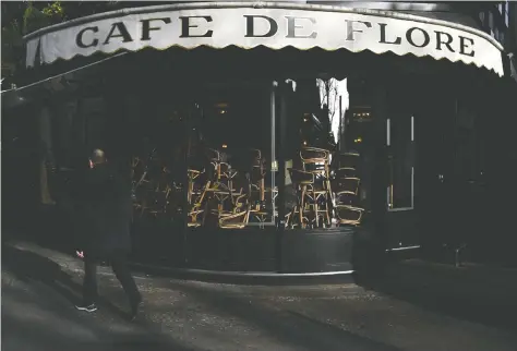  ?? PHILIPPE LOPEZ / AFP VIA GETTY IMAGES ?? Chairs are piled up Sunday inside the Café de Flore in Paris as cafés and restaurant­s shut down amid the spread of the novel coronaviru­s.
On Saturday, Prime Minister Edouard Philippe announced the closure of all non-essential public places in France.